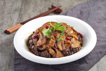 Braised pork belly in brown sauce in a white dish