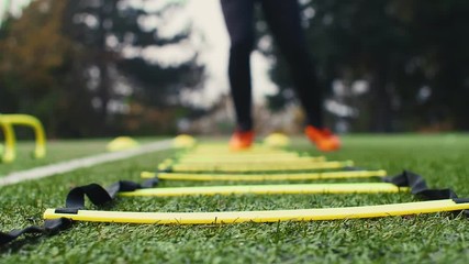 Soccer agility training equipment. Professional football player with agility ladder. 4k slow motion