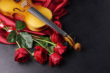 Fototapeta premium Violin and a bouquet of red roses on black. 