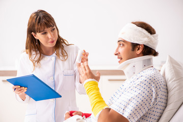 Young doctor examining injured patient 