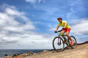 Mountain bike sport man riding MTB bicycle. Biking fitness athlete cyclist on mountain trail in...