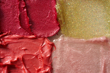 Smears of different colors are made with various lipstick isolated on a white background.