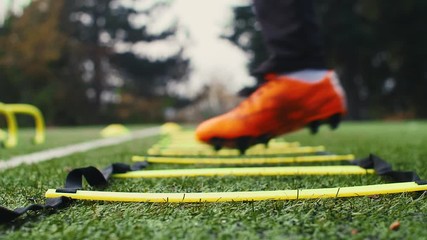 Soccer agility training equipment. Professional football player with agility ladder. 4k slow motion - Powered by Adobe