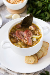 Thick pea soup with smoked meats in a white plate
