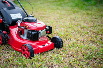 close up lawn mower in the park on the grass. over light [blur and select focus background
