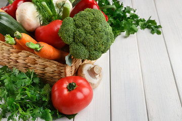 Wicker basket with vegetable assortment on wooden table