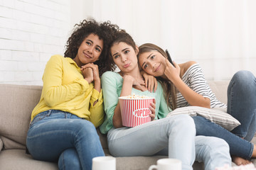 Girls watching cute movie and eating popcorn at home