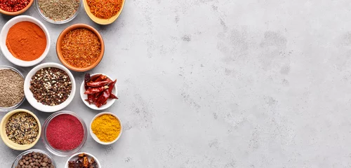 Poster Spices and condiments in bowls on grey background © Prostock-studio