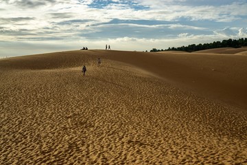 Backpacker in the Red Sand Dunes in Vietnam waiting for the Sunset