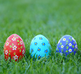 Handmade Painted Easter eggs on green spring grass. Space for text