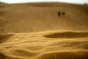 Sand Bokeh with Tourists walking on top a Sand Dune in the Background in Vietnam