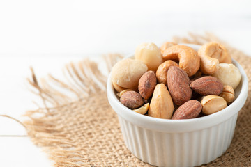 salted cocktail nuts on white wood background.