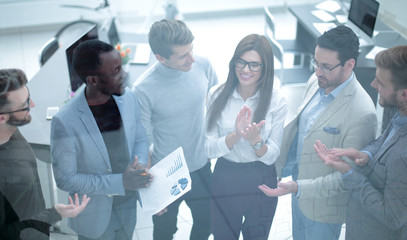 business team applauds, standing behind a glass wall