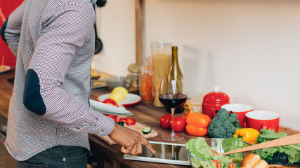 Black man searching recipe on digital tablet in kitchen