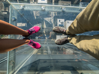 Tourists posing on a glass floor