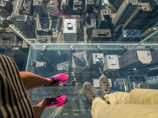 Tourists posing on a glass floor