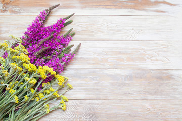 purple and yellow flowers on the table, tender shaby wooden background. Blank, greeting card