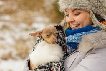 Woman hug warming her little dog in winter