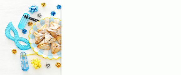 Purim celebration concept (jewish carnival holiday) over wooden white background.