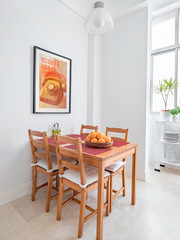 Cozy wooden table and chairs, picture frame in a spacious modern kitchen.