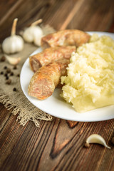 Grilled chicken sausage with mashed potato on wooden background. Healthy lunch or dinner. 