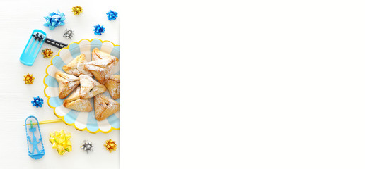 Purim celebration concept (jewish carnival holiday) over wooden white background.