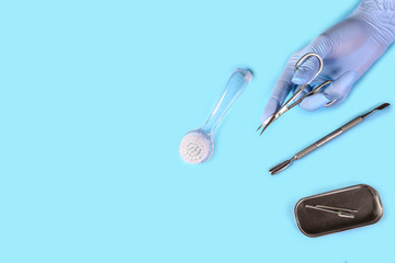 Manicure tool in the hands of the master. set of manicure accessories on blue background top view. flat lay composition with copy space. Composition for card with a place for text