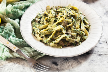 Tagliatelle pasta with spinach and mushrooms on a plate