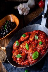 Baked mini meatballs in tomato sauce with basil