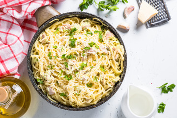 Pasta carbonara with bacon and cream sauce on white. 