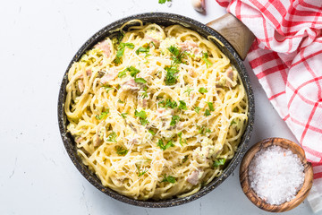 Pasta carbonara with bacon and cream sauce on white. 