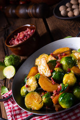 Fototapeta na wymiar Brussels sprouts potato pan with bacon in rustic style