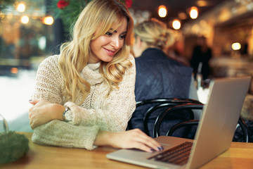 Woman working at laptop in cafe place. - Image