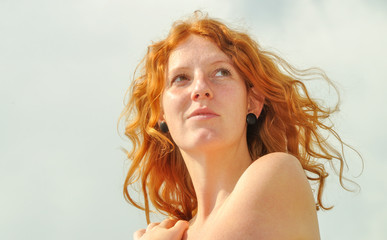 sehnsüchtigen lockigen Frau im Urlaub am Meer mit Textfreiraum