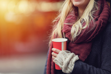 Close-up portrait of young blonde woman drinking coffe and enjoying the morning on the street. - Image