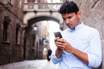 modern guy walks in city and communicates on smartphone