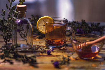 Black tea with lemon in a transparent mug, violet flowers, beaut