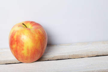 Ripe juicy apples. They lie on a wooden box. On a white background.