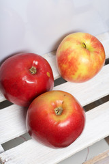 Ripe juicy apples. They lie on a wooden box.
