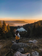 Young woman enjoying a sunset with a lake view