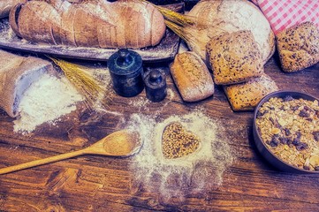 Bread and flour on a rustic wooden table.