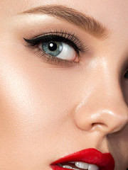 Portrait of young beautiful woman with evening make up. Red lips and eyeliner. Classic makeup...