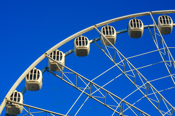 Big beautiful ferris wheel in the park against the blue sky.