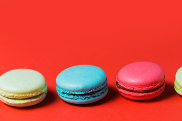 Closeup of French macaroons on red background with copy space