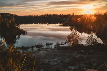 Fototapeta premium Sunset on the lake of basalt stone. Landscape on the lake in the autumn afternoon.