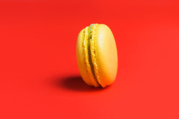 Closeup of yellow sweet macaroon on red background