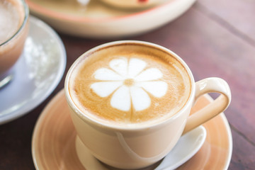 cup of hot coffee latte art on wooden table 
