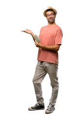 Man holding many bills extending hands to the side for inviting to come on isolated white background