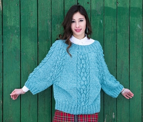 The beautiful model poses in a fashionable knitted sweater