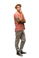 Man holding many bills showing a sign of closing mouth and silence gesture on isolated white background